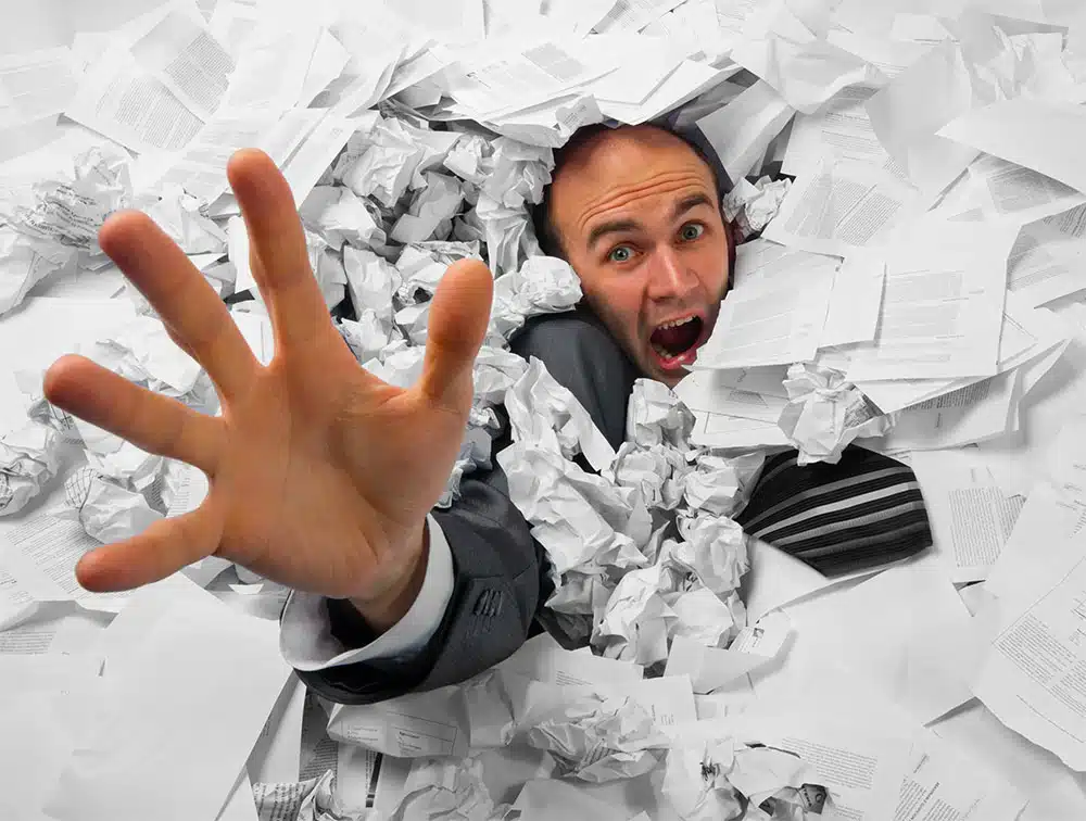 drowning-in-paperwork business owner working too many hours
